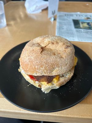 Breakfast sandwich on dos hermanos English muffin with vegan cheddar, bacon, mamas lil peppers, and garlic dill aioli   at Jet Black Coffee Company - Gateway in Portland