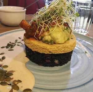 Medalhão de Grão de Bico e Berinjela Defumada, arroz negro e guacamole com queijo cremoso de castanhas fermentado com kefir  at Raw Porto Alegre in Porto Alegre