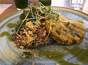 Risoto de Arroz Negro com queijo de castanhas cremoso, alho poro e cogumelos acompanhado de Medalhão de Grão de Bico e Couve com Crumesão at Raw Porto Alegre in Porto Alegre