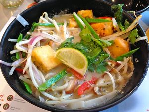 Yasai itame consists of rice noodles in a spicy green coconut and lemongrass broth topped with tofu and vegetables (stir-fried beansprouts, red and spring onions, bok choi, peppers, mushrooms and chillies) and garnished with coriander and lime. at Wagamama in Dartford