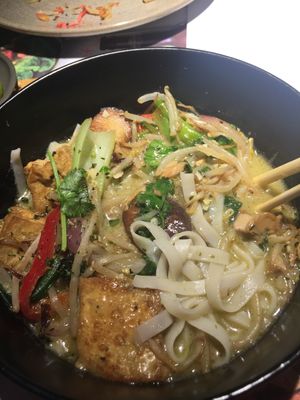 Vegan rice noodles in a spicy green coconut and lemongrass soup topped with tofu + vegetables, stir-fried beansprouts, red and spring onions, bok choi, peppers, mushrooms and chillies. garnished with coriander and lime at Wagamama in Dartford