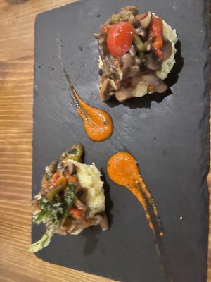 Causas Vegetarianas:

potato purée, aji Amarillo, roasted bell peppers, shitake mushrooms, caramelized onions & harissa sauce at Mama's Picanteria in Sitges