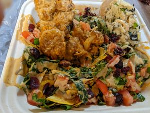 Build your salad bowl, massaged collard greens base, with red beans and rice, crab salad, sweet & spicy cauliflower, cranberries, tomatoes, seeds at Dajen Eats in Eatonville