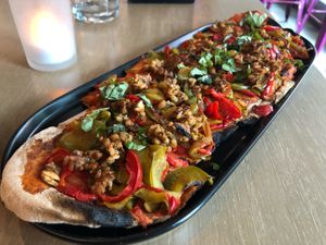 “Sausage & Pepper Flatbread” seemed a little overcooked and lacking flavor according to my partner. at GLAM Vegan in Miami