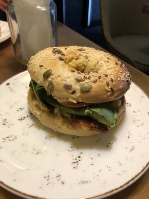 Bagel with hummus, avocado, tomato, and rocket at Holy Donut - Vokiečių in Vilnius