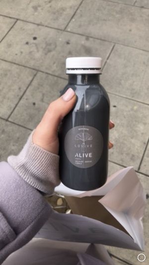 Black latte and matcha cookie in the bag and other goodies at Alive in Geneva