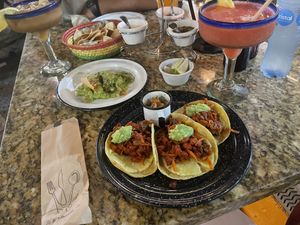 Vegan Al Pastor tacos, chips & guacamole, strawberry margarita (right), tamarindo margarita (left), salsa trio  at Casa Tequila in Cancun