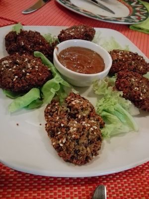 Balls of quinoa, sesame, flax seed and beans with sauce from coconut milk and peanut butter at Aztec in Athens
