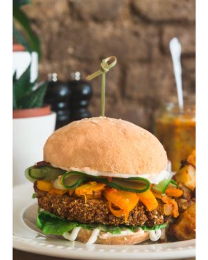 NEW Korean style Vegan Kimchi Burger. Crispy burger with fresh lemongrass, mixed vegetables, coriander and chilli, coated with black onion and sesame, spicy kimchi cabbage pickle and gochujang chilli sauce   at Miranda Cafe in North London