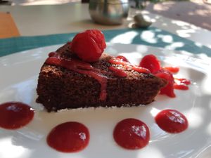 Vegan chocolate cake made in rice milk with fresh raspberries, served in Capannina. at Capannina in Riva Del Garda