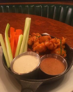 "Vegetarian Wings" 
Cauliflower bites covered in buffalo sauce with a side of house-made peanut sauce and a blue cheese dipping sauce 
(blue cheese sauce can be substituted for vegan chipotle aioli)  at Duino Duende in Burlington