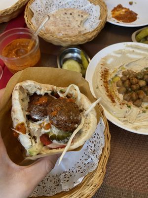 Falafel pita sandwich ( whole) the filling: falafels, hummus, salad, pickles (and added extra hummus from the plate & hot sauce) at Falafel TLV in Hong Kong Island