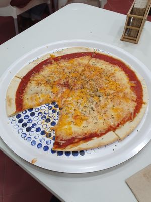 The pizza looked so good, that i had to take a bite before taking a picture. Pizza with three cheeses.  at Pizzeria La Faina in Malaga