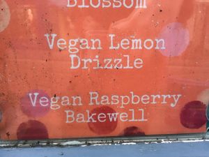 Vegan cakes listed in window at The Origami Cafe & Gift Shop in Alnwick