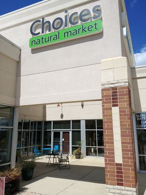 The front of the store has a seating area with bistro tables. at Choices Natural Market in Loves Park