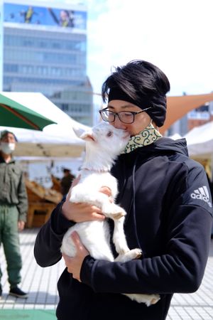 My husband holding a sweet baby goat. at Farmer's Market - UNU in Tokyo