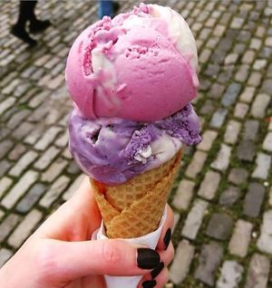 Raspberry and white choice cookie dough on top of Lemon and Blueberry ripple on a gluten free cone at Ice Green in Cardigan