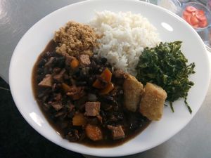 We always have one plate of the Day at lunch time and often goes the same by night. This was Feijoada Preta with Rice, Banana, Couve Galega and Farofa. 5€ a plate.  at Pecado Saudável in Porto