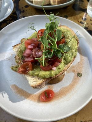 Avocado toast on sourdough w pickled onion, tomatoes & had potato wedges underneath   at Lemon Leaf in Kinsale