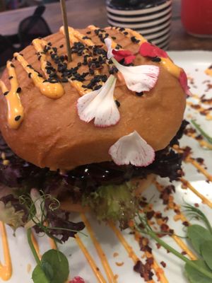 Close up of the burger with some petals on top of the bun. at The Organic Boho in Copenhagen