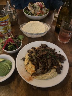The chicksteak hummus plate with a side of avocado. Across is the cauliflower of life Salad  at Chickpea Restaurant in Vancouver