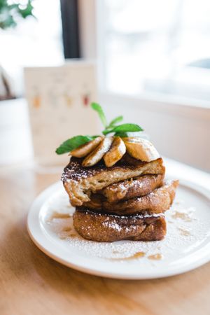 FRENCH TOAST- Delicious slices of bread are soaked in a mixture of almond milk and organic sugar, 
then pan-fried until they turn crispy on the outside. To top it all off we add a pile of sautéed bananas sprinkled with cinnamon, a drizzle of Canadian maple syrup & homemade coconut whipped cream. at Chickpea Restaurant in Vancouver