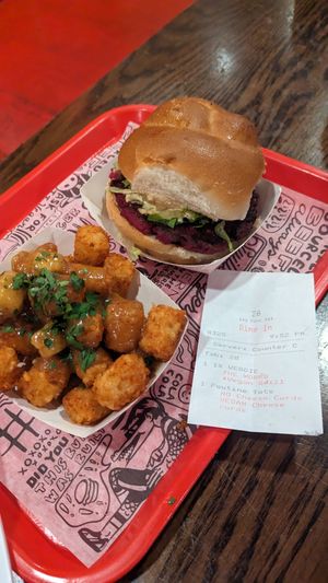 Poutine tots w tofu curds and vegan veggie burger at The Playhouse & Swillburger in Rochester