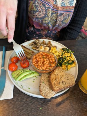 Brunch plate with scrambled tofu, mushrooms, sausages, white beans, bread, grilled tomatoes and avocado.  at Goji Lounge Cafe in Lagos