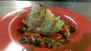 Vegan friendly Wedge Salad with iceburg lettuce, onion, tomato and black olives drizzled with Tuscany balsamic vinaigrette. Yum! at Graffiti's Pizza in Mcdonough
