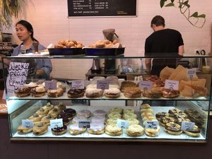 Donut case with vegan options on bottom shelf at Donut Shop in Prague
