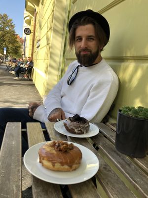 Tables on the sidewalk to enjoy the local neighborhood and culture. Tree lined street with some cute shops in the neighborhood   at Donut Shop in Prague