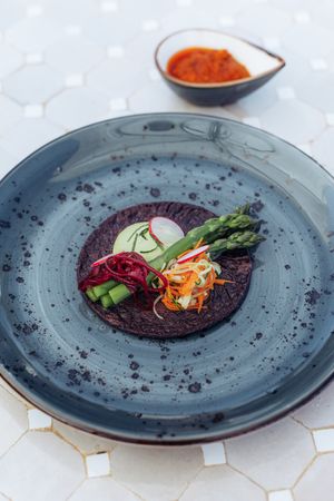 Black rice dosa with pickled root vegetables and 'Ramallet 'tomatoes & bell pepper sauce at Cal Reiet's Table in Mallorca