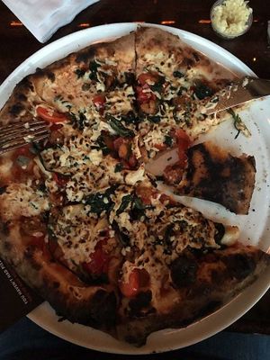 Vegan pizza with vegan sausage, capers, peppers, onions, spinach and spices. at MidiCi in Katy
