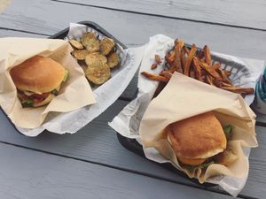 Buffalo tempeh burger with pickle chips and BBQ western burger with fries at E Burger in Columbus