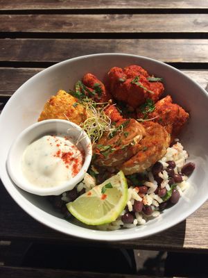 Buddha bowl - bbq cauliflower, tempeh, rice with black beans, corn on the cob with a creamy white sauce (tasted kind of like sour cream or tziki).  at Comptoir Veggie in Paris