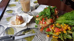 Hummus sandwich, ice latte and half eaten cinnamon bun at Café Nowhere in Enskede