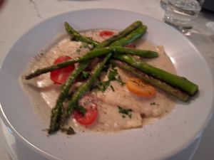 White Bean Ravioli in a garlic creamy "parmesan" sauce topped with grilled asparagus and cherry tomato at P.S. Kitchen in New York City