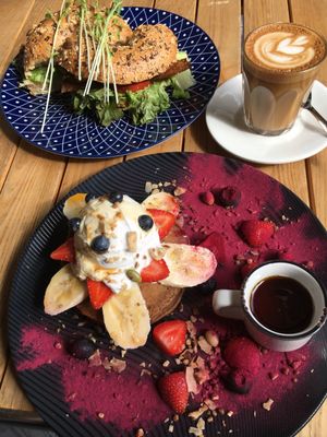 Fruit pancakes (bottom), vacon bagel (top), and almond milk latte at Gathered Kitchen in Glebe
