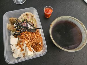 Takeaway vegan dumplings soup (14.2€), you pour the liquid into the box with ingredients. Noodles not visible on the bottom. Chili for spiciness. at Tokyo Street in Helsinki
