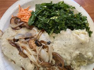 Chick’n fried steak with added mushrooms and onions, mashed potatoes, kale saladd  at Green Vegetarian Cuisine - Quarry Market in San Antonio