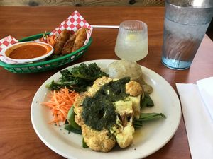 Cauliflower Steak, Not-zerella Sticks, pineapple mocktail, and a water. at Green Vegetarian Cuisine - Quarry Market in San Antonio