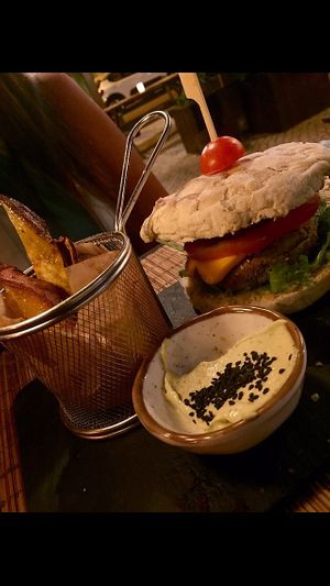 Quinoa black bean burger, vegan cheese with sweet potato fries😋 at Raizes in Quarteira