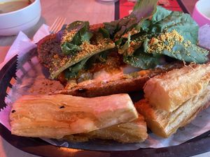 Meatball sandwich with fried yucca. Hard to see the meatballs under the greens. Meatball is made of beets. at Huacamole Vegan Food in San Pedro
