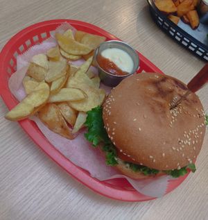 Chicken burger with potato wedges and dip at Huacamole Vegan Food in San Pedro