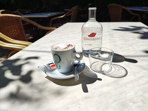Cappuccino (oat milk) and water. at La Mar de Vins in Mallorca