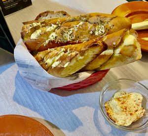 Massive bread basket with 6 slices of normal bread underneath the garlic bread!  at Veggie Momi in Albufeira
