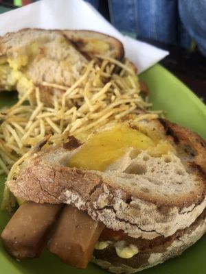 Vegan grilled cheese sandwich with tomatoes, onions, mustard and vegan sausages  at Veggie Momi in Albufeira