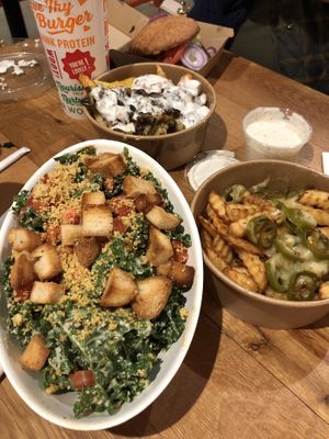Kale Caesar salad with nutritional yeast parmesan, and fries smothered in cheese and stuff. Yum! at Next Level Burger - Roosevelt in Seattle