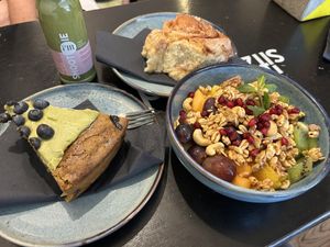 Brunch time - soy yoghurt bowl topped with fruits and granola, slice of pistachio cake and green smoothie  at Ready in Luxembourg City