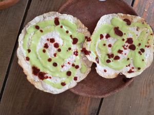 Crunchy tostadas with sesame paste and guac, I sprinkled on some red sauce :) at Schizandra in Oaxaca